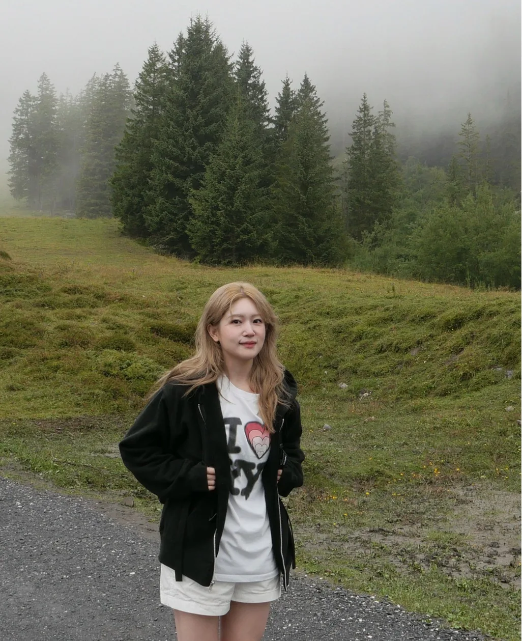 Jenn Choi standing on a mountain path in the fog